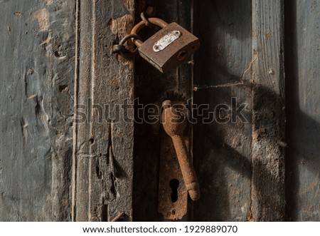 Wooden door locked with old rusty padlock. Vintage padlock. Security concept