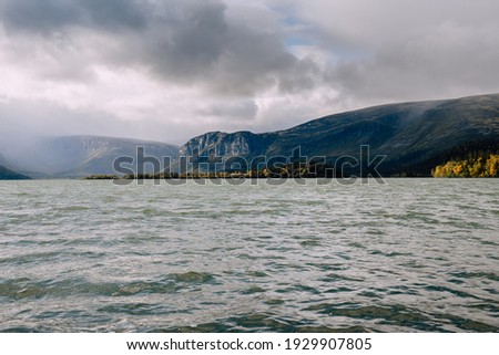 Foggy mountains on the background of the lake and cloudy sky. Mountain landscape in Kola Peninsula, Arctic, Lovozero