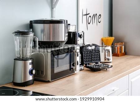 Different household appliances on table in kitchen Royalty-Free Stock Photo #1929910904