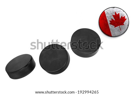 Canadian hockey pucks lined up in a row on white background 