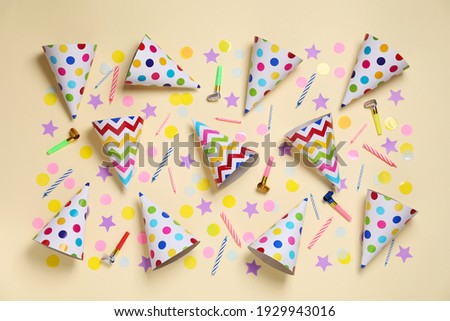 Flat lay composition with party cones and confetti on beige background