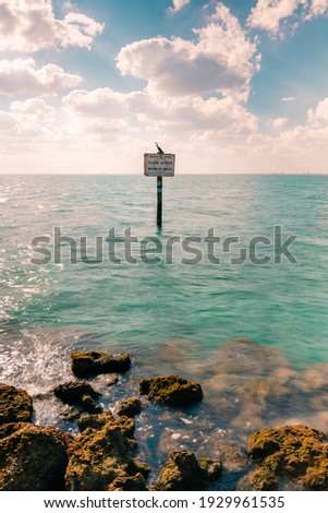 Landscape photo of the ocean with a sign in Key Biscayne Florida