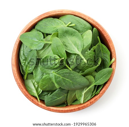 Spinach leaves in a wooden plate on a white. Top view. Royalty-Free Stock Photo #1929965306