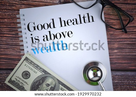 Selective focus image of stethoscope,spectacles,bank note and note book with Good health is above wealth wording on a wooden background. Health and life concept