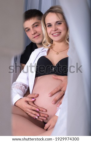 Beautiful and funny lovers are waiting for a child. Pregnant happy girl and her husband.