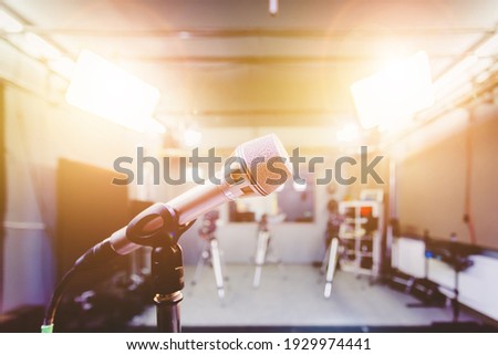 Professional microphone in recording tv studio, studio lights in blurry background