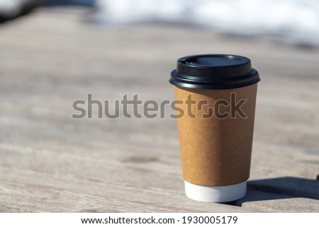 disposable coffee cup in the park on a wooden surface