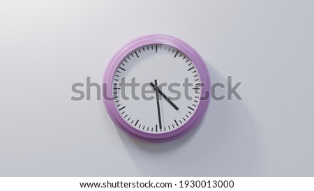Glossy pink clock on a white wall at twenty-nine past four. Time is 04:29 or 16:29 Royalty-Free Stock Photo #1930013000