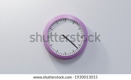 Glossy pink clock on a white wall at twenty-two past four. Time is 04:22 or 16:22 Royalty-Free Stock Photo #1930013015