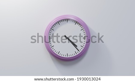 Glossy pink clock on a white wall at twenty-three past four. Time is 04:23 or 16:23 Royalty-Free Stock Photo #1930013024