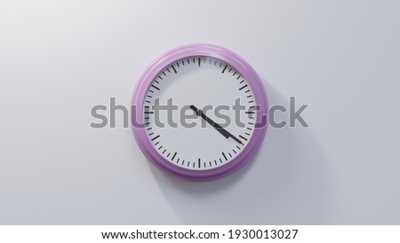 Glossy pink clock on a white wall at twenty-one past four. Time is 04:21 or 16:21 Royalty-Free Stock Photo #1930013027