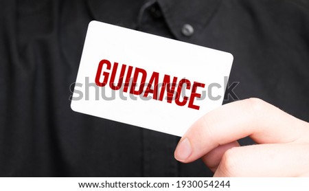 Businessman holding a card with text GUIDANCE,business concept
