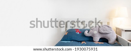Minimalistic  room in white colors. Baby bed with blue bed linen, abstract background