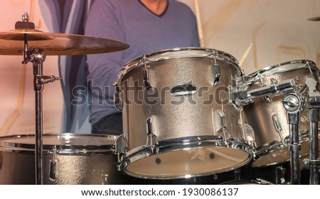 Male hand and drums with metal plates.