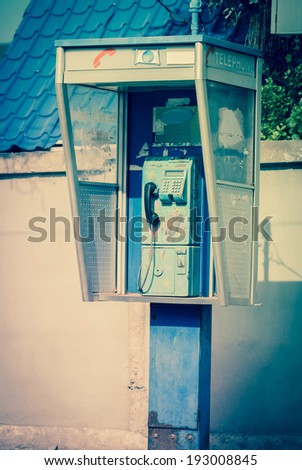 Aged and vintage photo of old public phone booth 