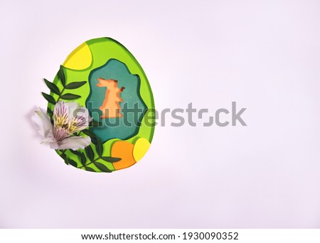 Design for the holiday Happy Easter. Paper art. Egg and rabbit shape cut from paper. Framed with natural alstroemeria flowers and plants. Great decorations for your design projects.