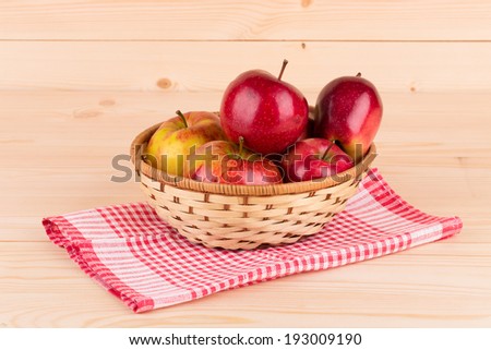 Fresh red apples in basket on wood. Whole background.