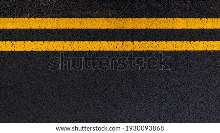Yellow no parking lines on freshly laid tarmac road. Royalty-Free Stock Photo #1930093868