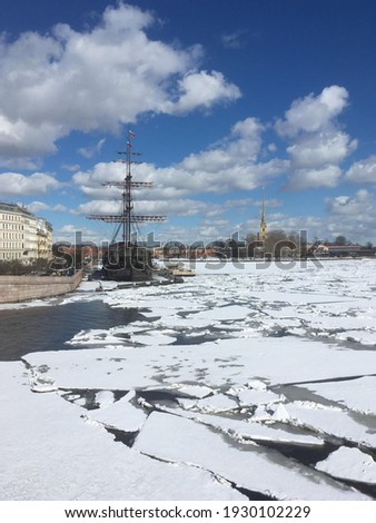 Cracked ice on the Neva River, view of the ship and the Peter and Paul Fortress in St. Petersburg.  Sunny march day