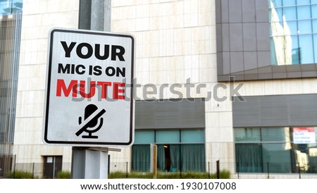 Your mic is on mute sign in a downtown city setting Royalty-Free Stock Photo #1930107008
