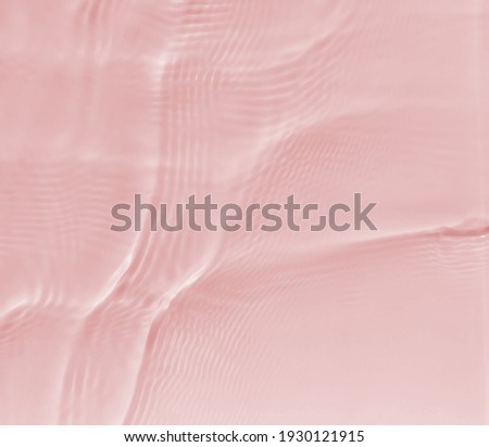 Subtle pink texture of light-shadow pattern of sunlight reflection from rippled water surface. Beautiful natural pattern with 3D feeling. 
