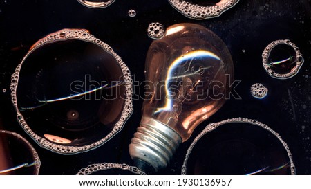 Burnout idea concept wallpaper. Light bulb and soap bubbles foam on glass surface isolated on black background. Bulbs concept image. Nightclub abstract Wallpaper