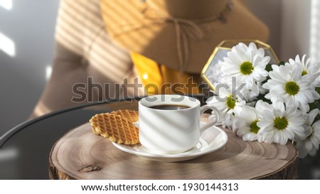 White cup with black coffee. Blue iPhone 12 Pro Max on the table.
Morning coffee, breakfast, cookies, flowers, white daisies, a wicker hat. Summer sunny background. 