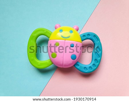 children's toy on a pink-blue background.  Toy in the form of a colored beetle.  Beautiful blue pink tones