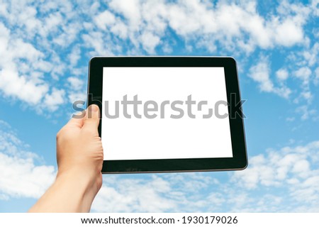 Close-up Tablet in hand against the background of the sky