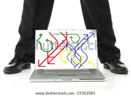 Man's feet on either side of laptop computer.  Screen showing red, blue, green and yellow arrows.