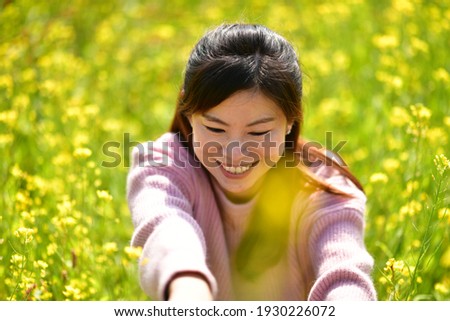 Delighted girl in the yellow flower bed