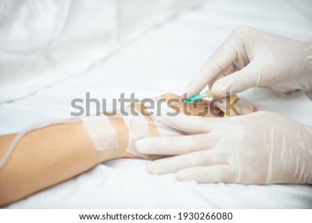 A nurse gentle injection with the medical into patient’s hand, The Dr. giving an vaccine to patient while lying in Hotpital bed.
