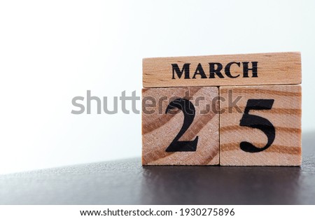 Day 25 of March month, Wooden calendar with date on the desk.