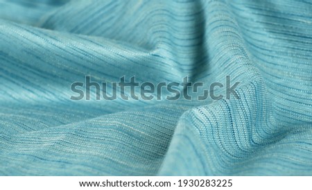 Close up detailed cloth texture of green shiny cloth. Continuous circular elastic weave material. Royalty-Free Stock Photo #1930283225