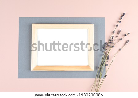 Horizontal wooden photo frame with white blank card and flowers on pastel pink background. Mock up poster frame. Stylish template . High quality photo