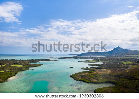 Aerial picture of the east coast of Mauritius Island. Beautiful lagoon of Mauritius Island shot from above. Boat sailing in turquoise lagoon.