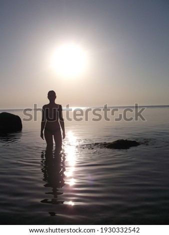 Silhouette of a girl against the backdrop of the setting sun. High quality photo