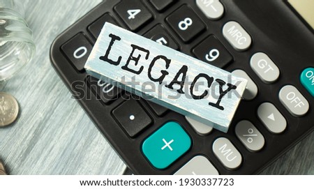 Word LEGACY on Wooden Block on calculator with shadow. Last will heritage Concept. Royalty-Free Stock Photo #1930337723