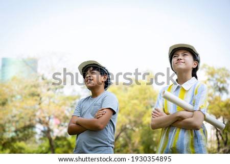 Indian boys and caucasian girl wearing protective helmet and hold construction. The child dreams of a career as an engineer and architect. Life planning and goal concept