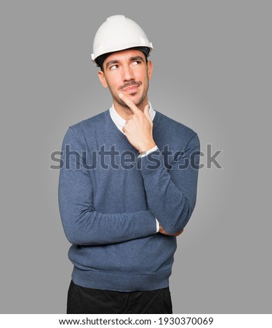 Young architect making a gesture of doubt Royalty-Free Stock Photo #1930370069