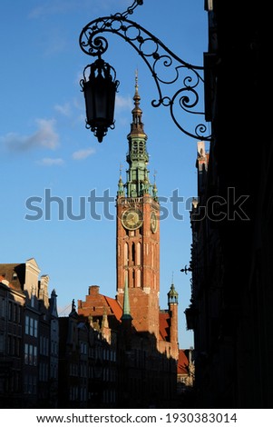 Black silhouette of a street lamp on Dluga Street in Gdansk. In the background - the Main Town Hall tower. Poland