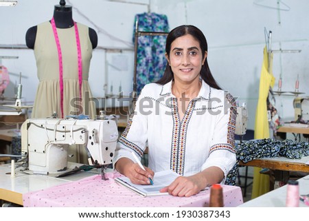 Female fashion designer drawing a sketch in her workshop