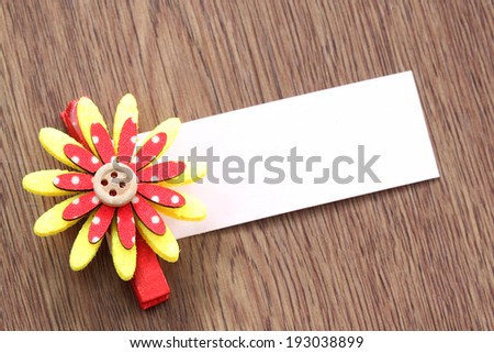 Red and yellow of artificial flowers and note paper stuck on dark wood pattern background.