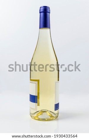 Beautiful burgundy style bottle of  white wine on white surface and background