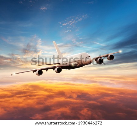 Passenger jetplane flying above clouds in sunset. Beautiful sunset scenery, transportation and fast travel concept. Royalty-Free Stock Photo #1930446272