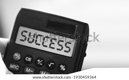 Calculator with word SUCCESS on its display. Business concept.