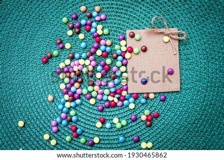 Colorful sweet bonbons treat and empty cartoon note greeting card for the Holiday. Above flat lay view. Copy space
