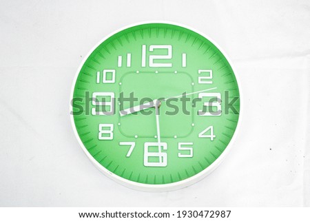 Front view of a minimalist green wall clock