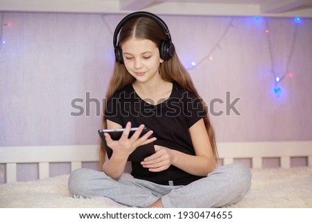 Girl in headphones, focus on the face of the child.
