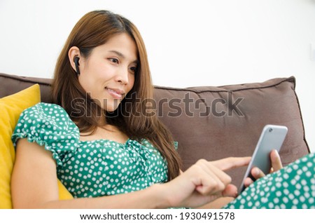 Woman looking at smartphone.While using headphone.Communication concept.